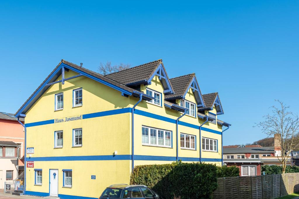 ein gelbes Haus mit schwarzem Dach in der Unterkunft Haus Jasmund in Binz