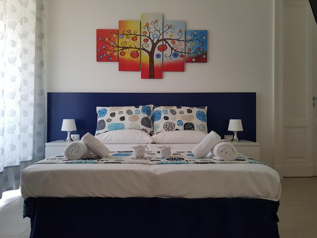 sypialnia z dużym łóżkiem z dwoma obrazami na ścianie w obiekcie B&B Flora w mieście Piazza Armerina