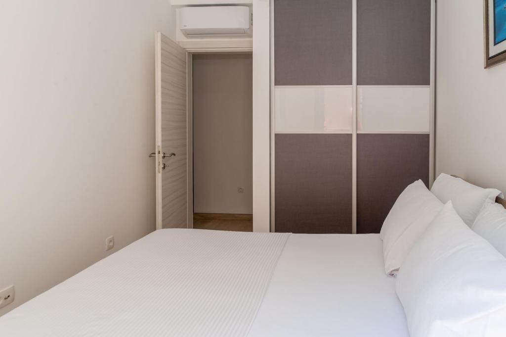 a bedroom with a white bed and an open door at Minka in Kotor