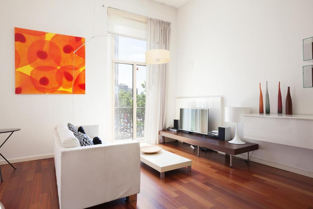 a living room with a white couch and a tv at Akira Flats Plaza Catalunya Centric apartments in Barcelona