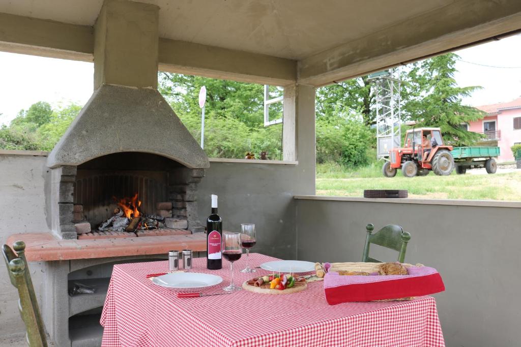 einen Tisch mit einem roten Tischtuch und einem Kamin in der Unterkunft Villa Zwei Zedern in Pićan