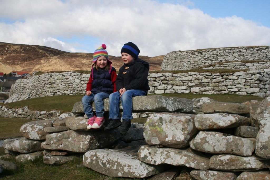 twee kinderen op een stenen muur bij 16 Mounthooly Street in Lerwick