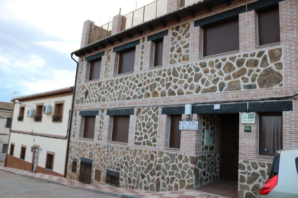 un edificio de ladrillo con una fachada de piedra en Casa Rural "Vallecasar" en Los Navalucillos