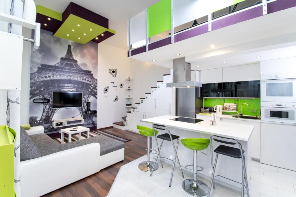 ブダペストにあるDesign Apartment Nyugatiの白いキャビネットと緑のスツール付きのキッチン