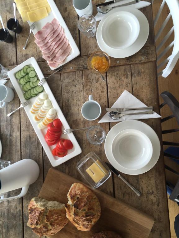 a table with plates and food on top of it at Mengi Countryside in Kjarnholt