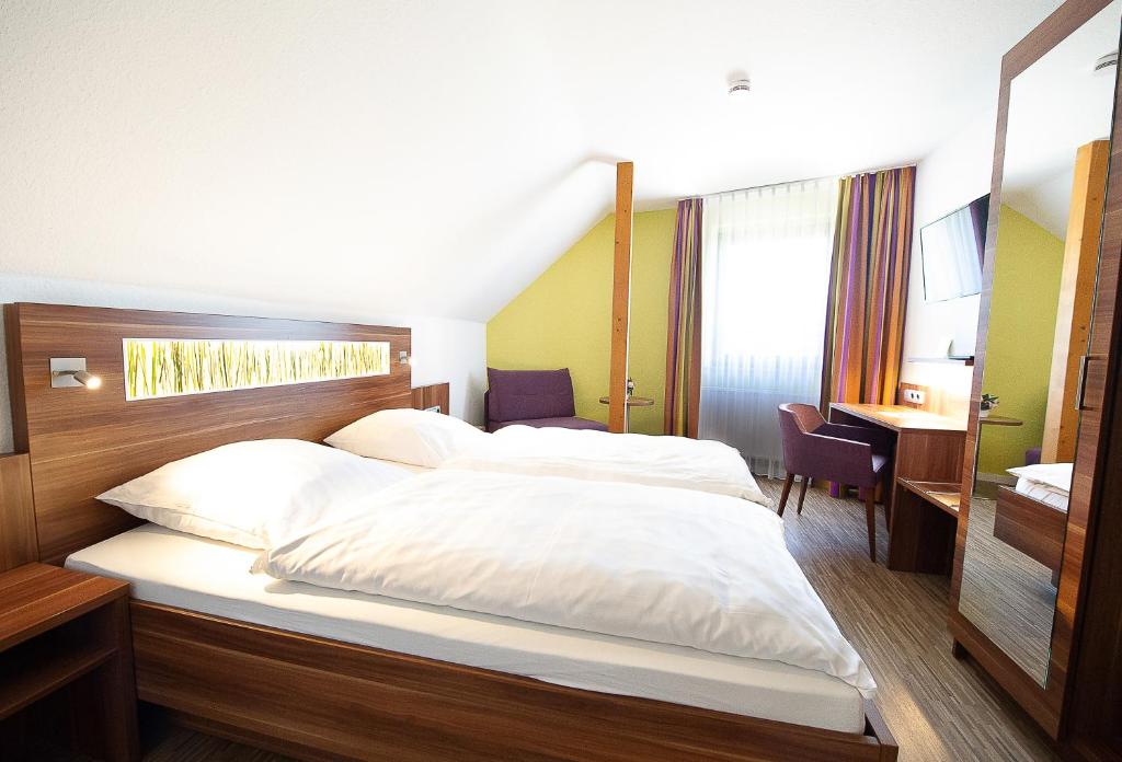 a bedroom with a large bed with white sheets at Hotel Meyer in Hildesheim