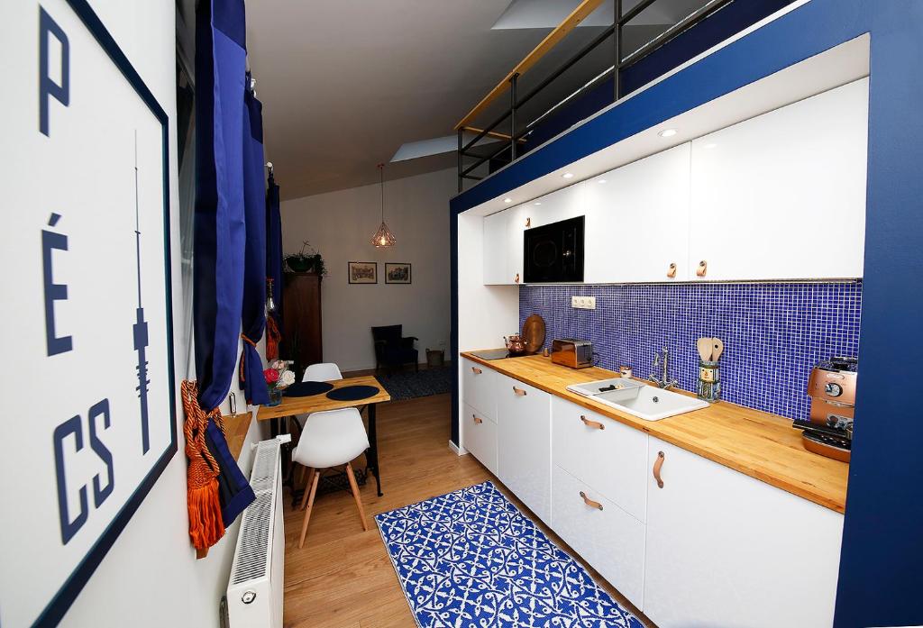 a kitchen with a sink and a counter with a table at Mini Flathotels in Pécs