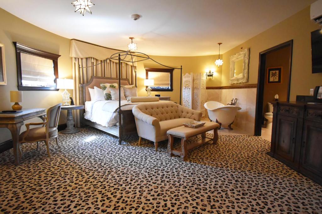 a bedroom with a bed and a sink and a tub at The Detroit Club in Detroit