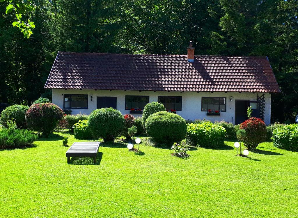 una pequeña casa blanca con un banco en un patio en Lucky Lady en Spital am Pyhrn
