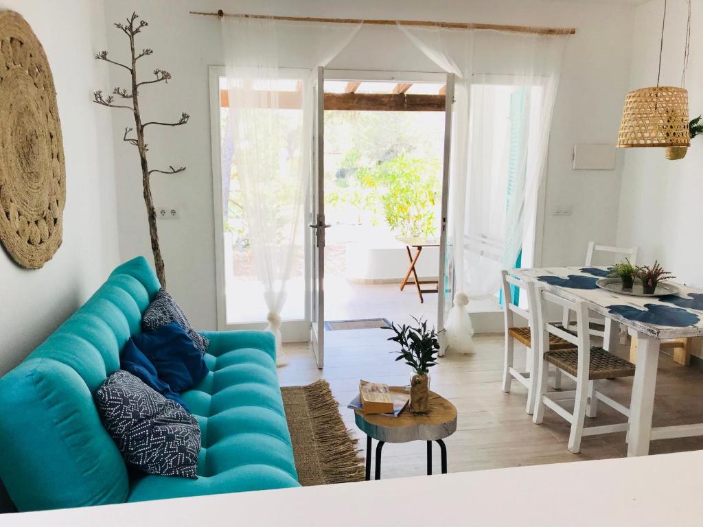 a living room with a blue couch and a table at Cabaña Cala Saona in Sant Francesc Xavier