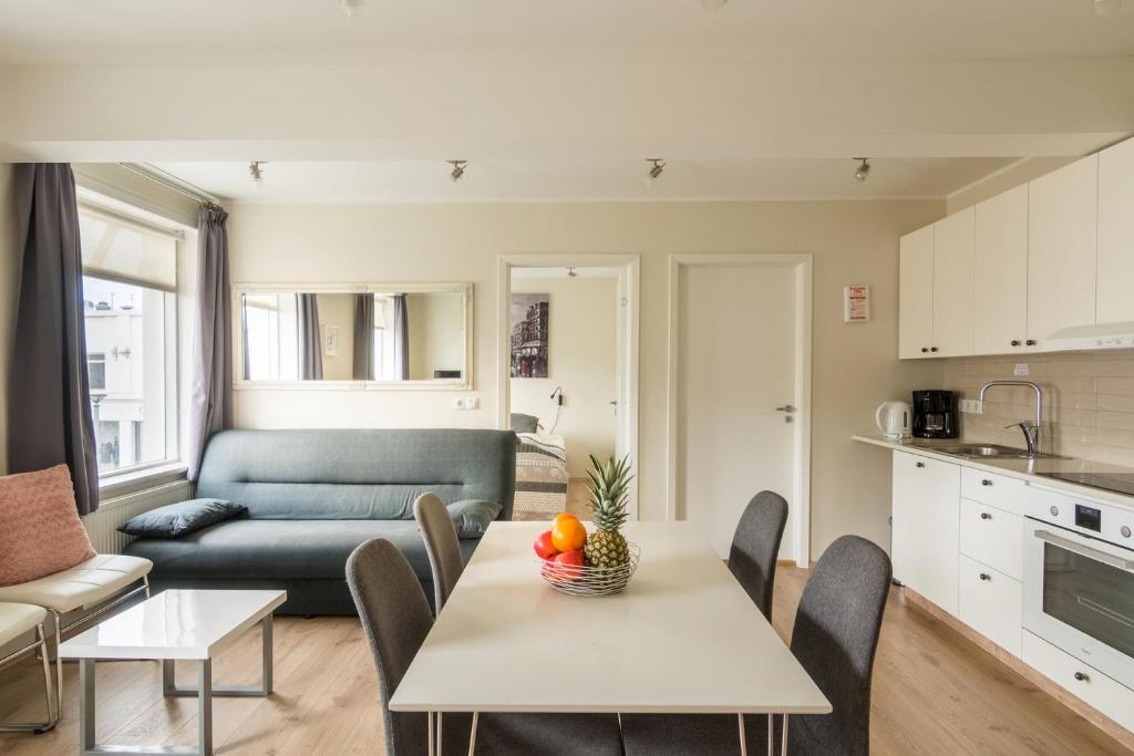 a kitchen and a living room with a table and chairs at Acco Town Square Apartments in Akureyri
