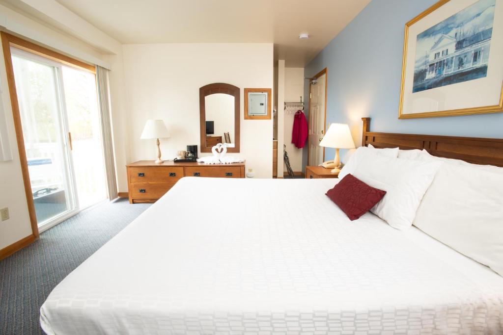 sypialnia z dużym białym łóżkiem i lustrem w obiekcie USA Inn w mieście Wells