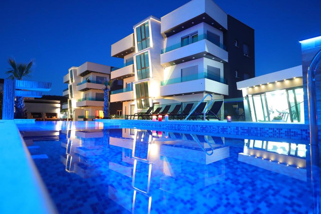 un hôtel avec une piscine en face d'un bâtiment dans l'établissement Boutique Apartments Blitz, à Bibinje