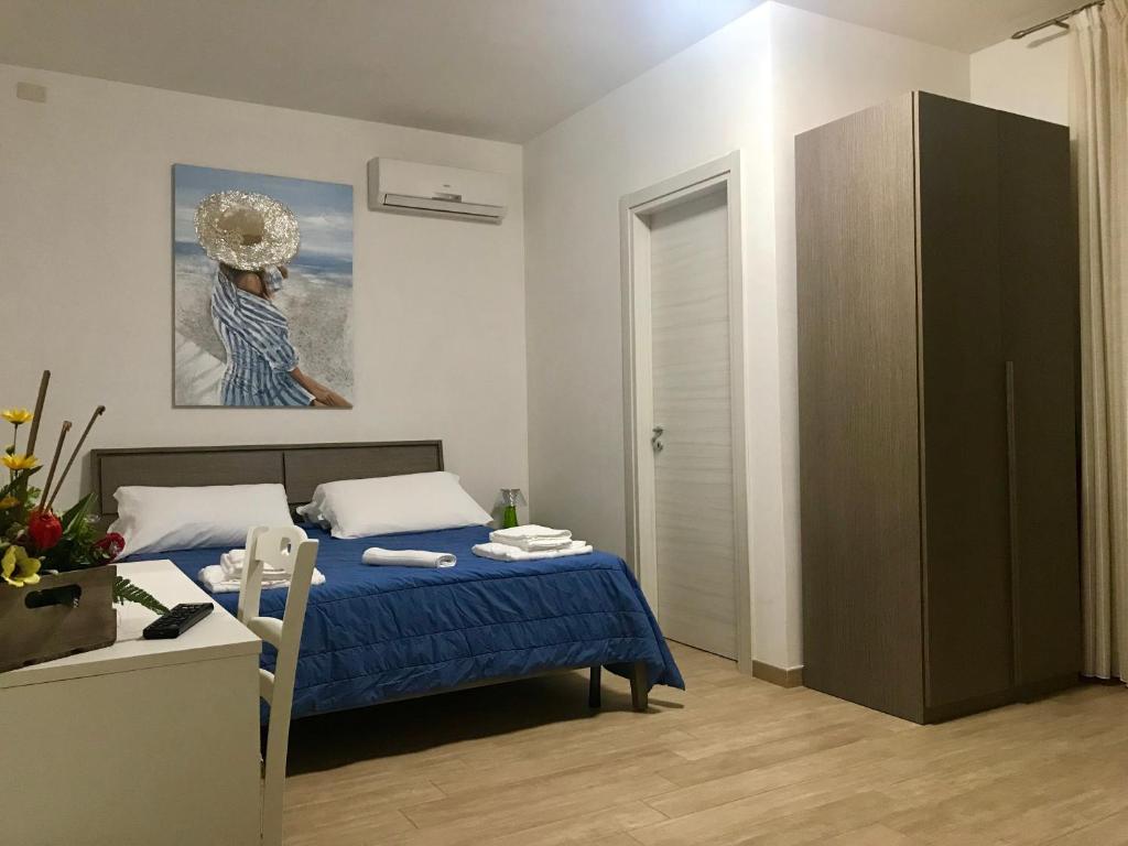 a bedroom with a bed and a table and a painting at Baia Dell'Orso in Torre dell'Orso