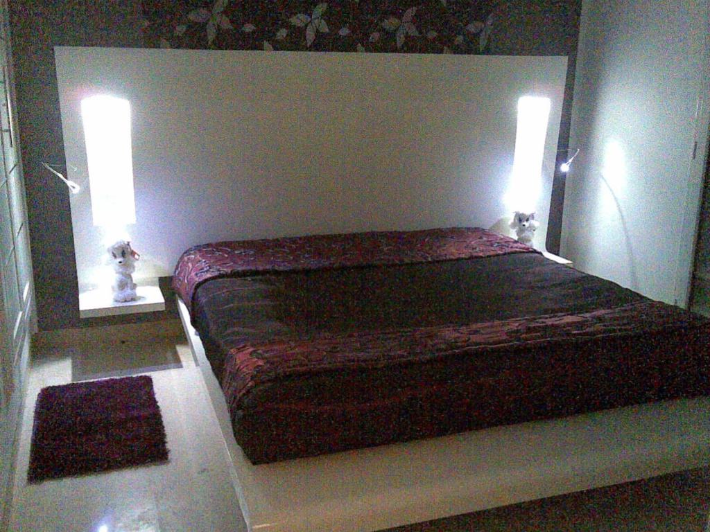 a bedroom with a bed with two lights on it at Happy House Ennasr in Ariana