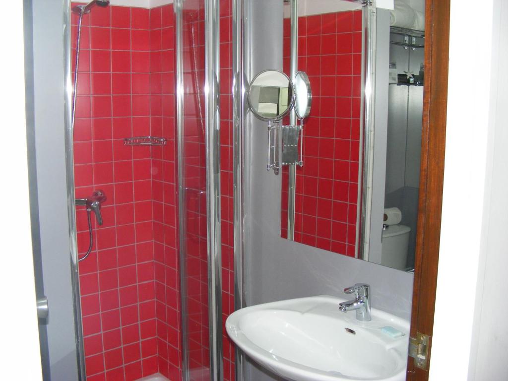 a bathroom with a shower, sink, and mirror at Rocamar Exclusive Hotel & Spa - Adults Only in Albufeira