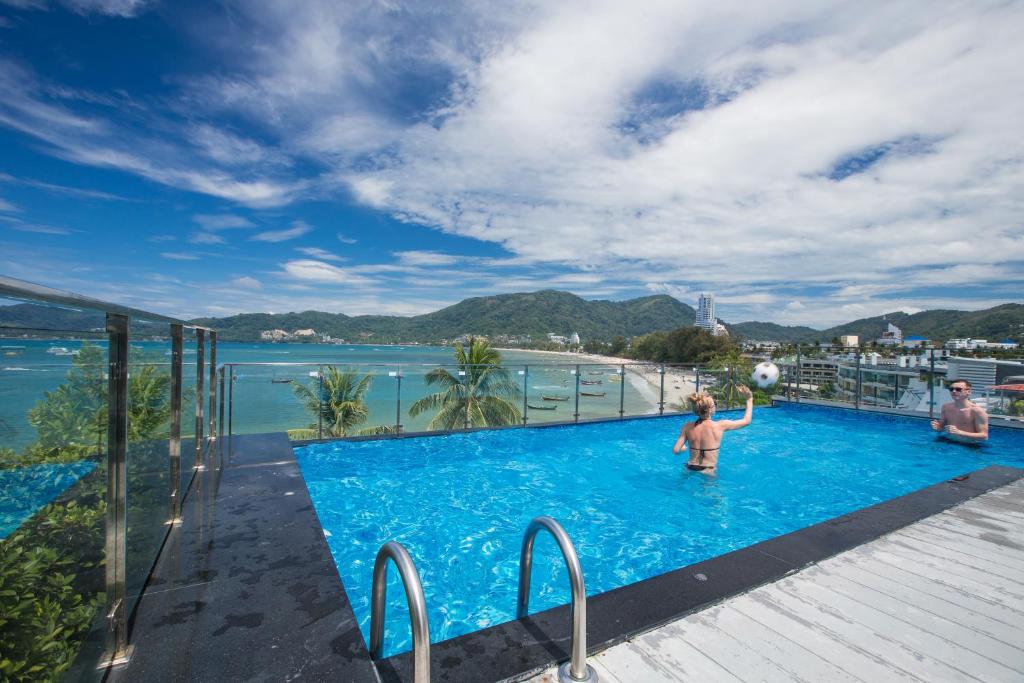 Ein Mann und ein Kind spielen im Pool in der Unterkunft Patong Signature Boutique Hotel in Patong Beach