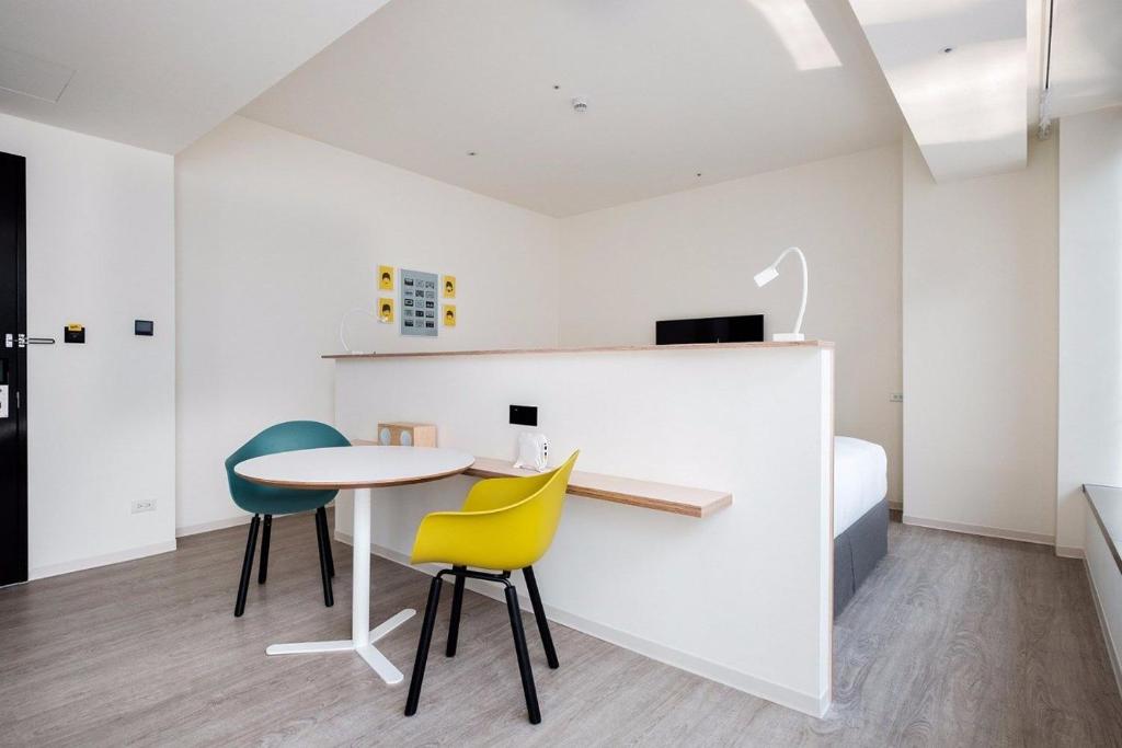 a room with a table and two chairs and a bed at amba Taipei Songshan in Taipei