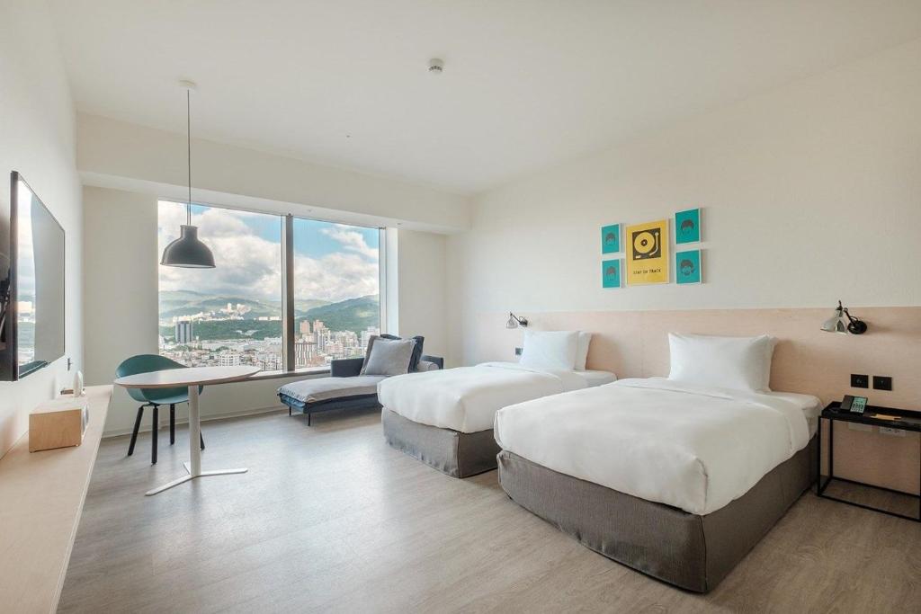 a hotel room with two beds and a desk at amba Taipei Songshan in Taipei