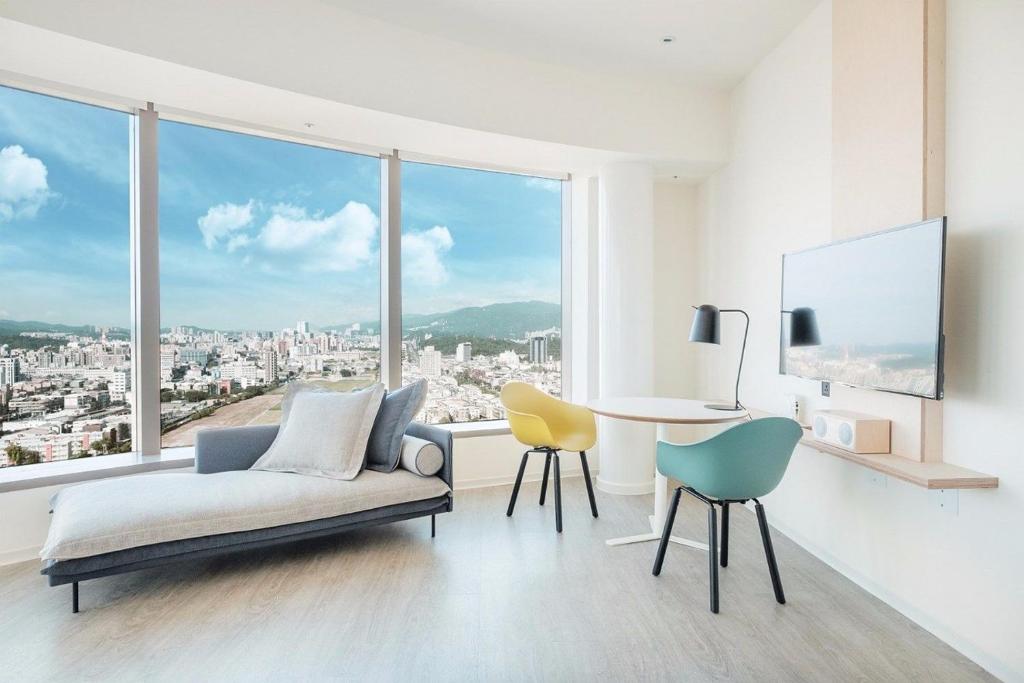a living room with a couch and a table and chairs at amba Taipei Songshan in Taipei