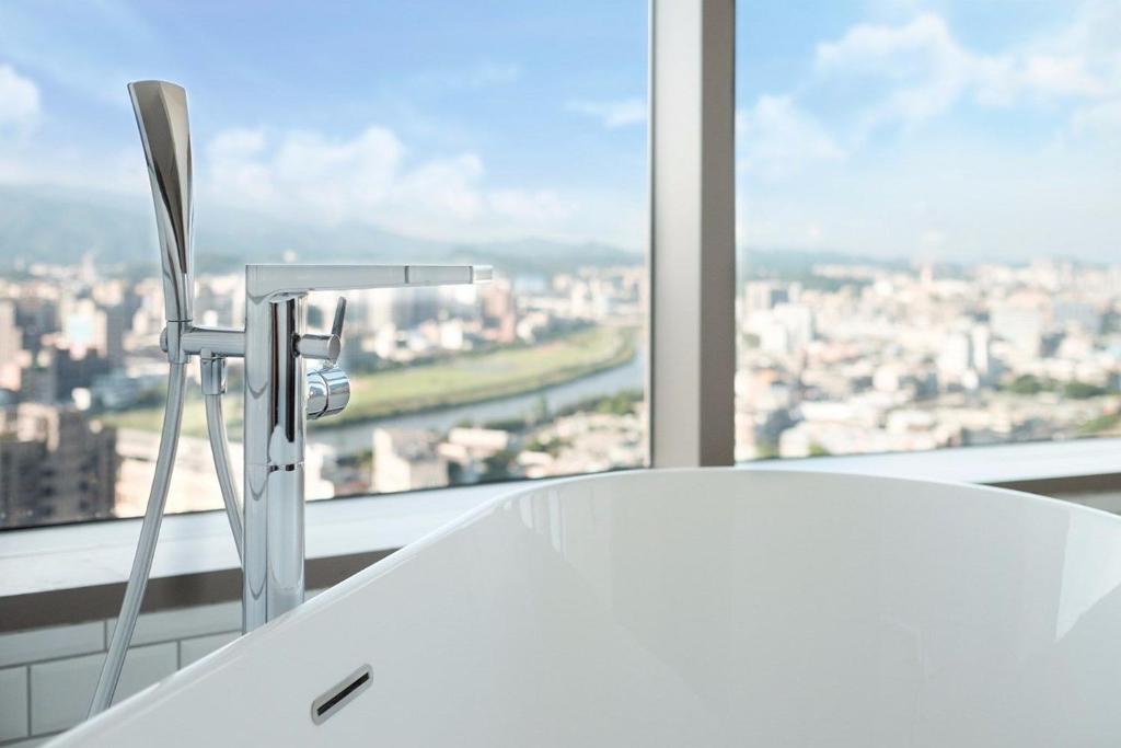 a bathroom sink with a view of a city at amba Taipei Songshan in Taipei
