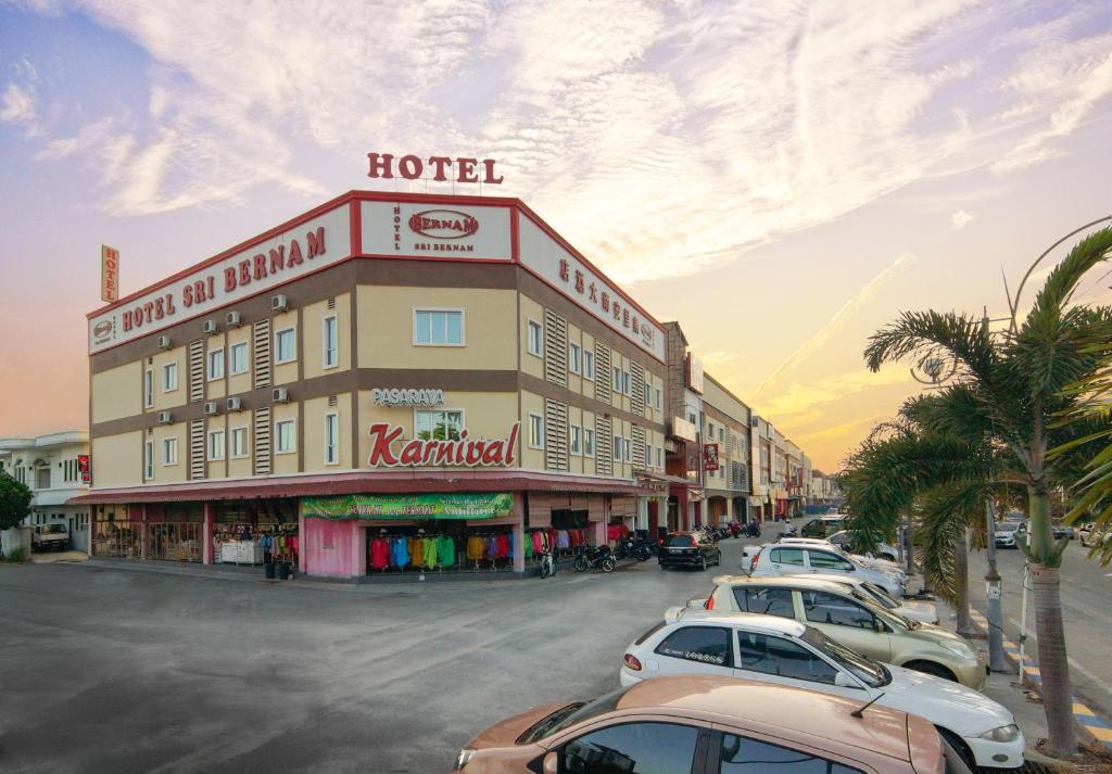 una fila de coches estacionados frente a un hotel en Hotel Sri Bernam, en Sabak Bernam