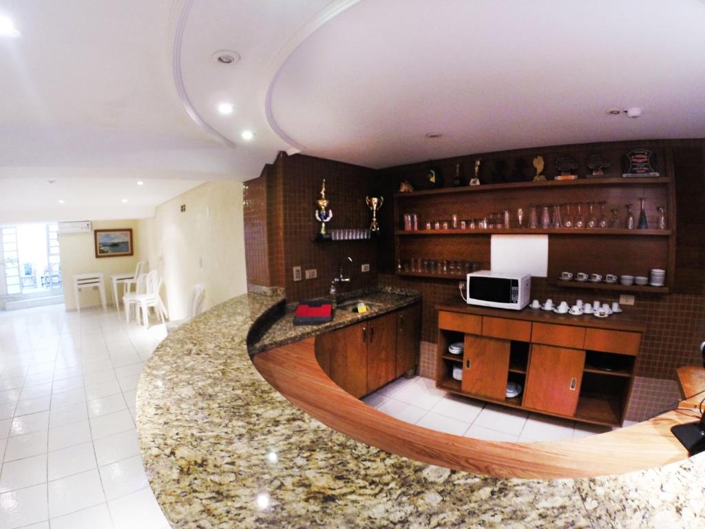 a kitchen with a circular counter and a microwave at Hotel Praia e Sol in Matinhos