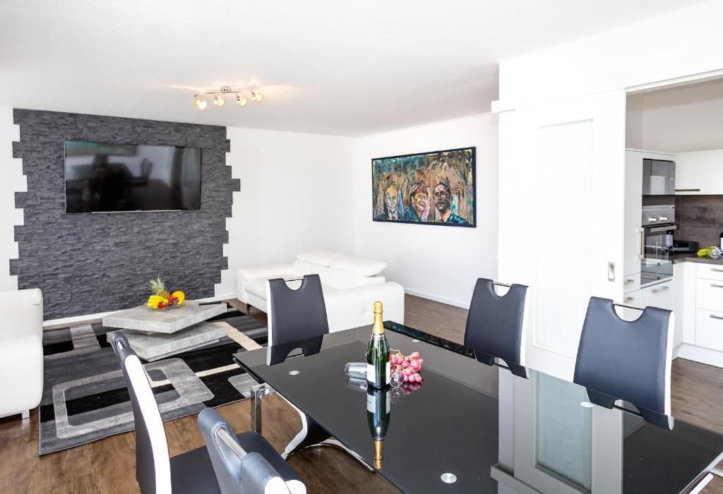 a living room with a dining table and a kitchen at Lifestyle-Appartement Meersinn in Waren
