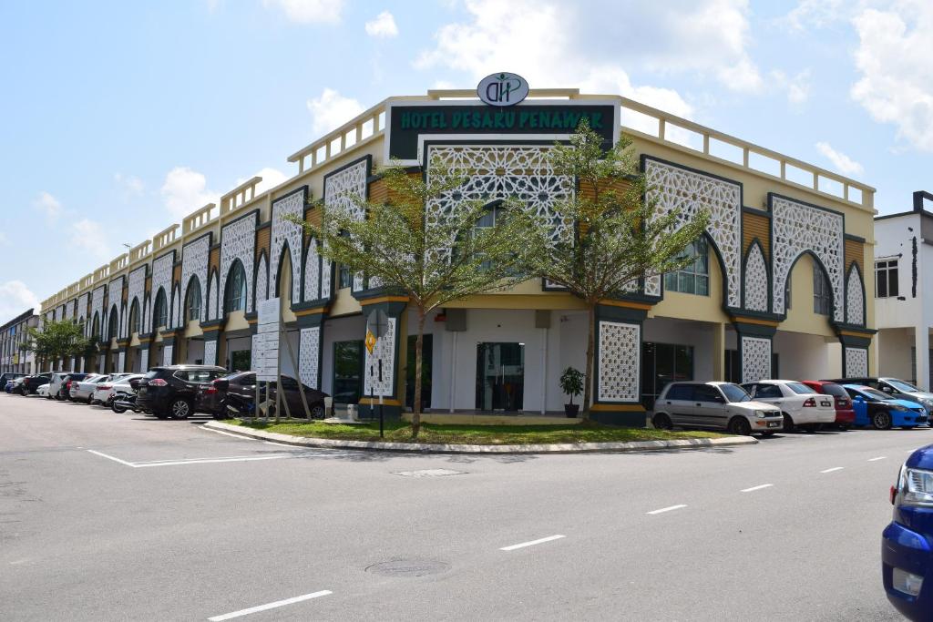 a large building with cars parked in a parking lot at Hotel Desaru Penawar in Desaru