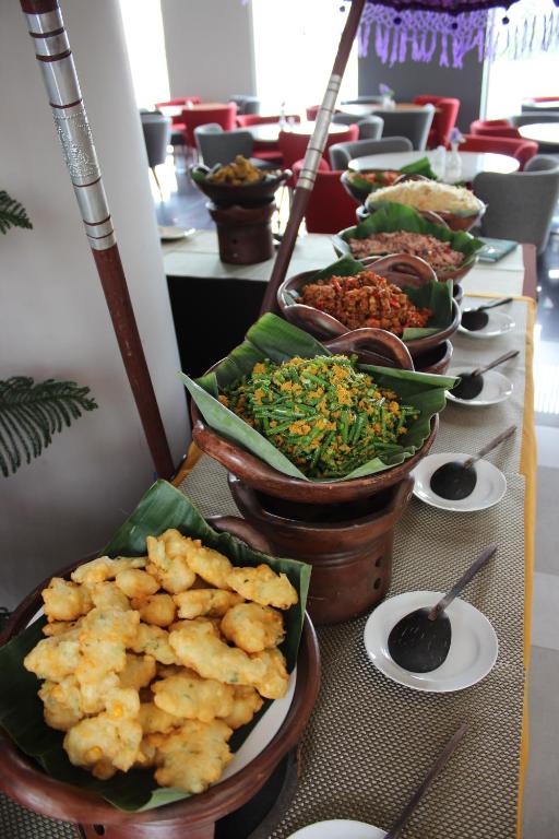 a buffet line with plates of food on a table at Kyriad Hotel Airport Jakarta in Tangerang