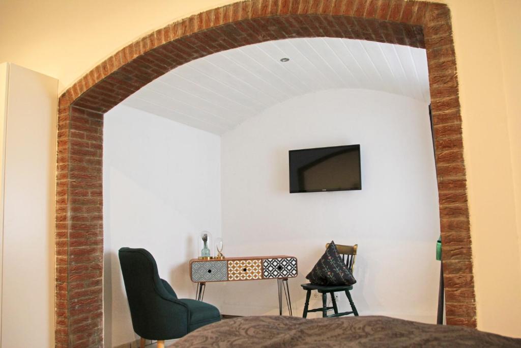a room with a brick archway with a television on a wall at Pension Kupferkanne in Dingolfing