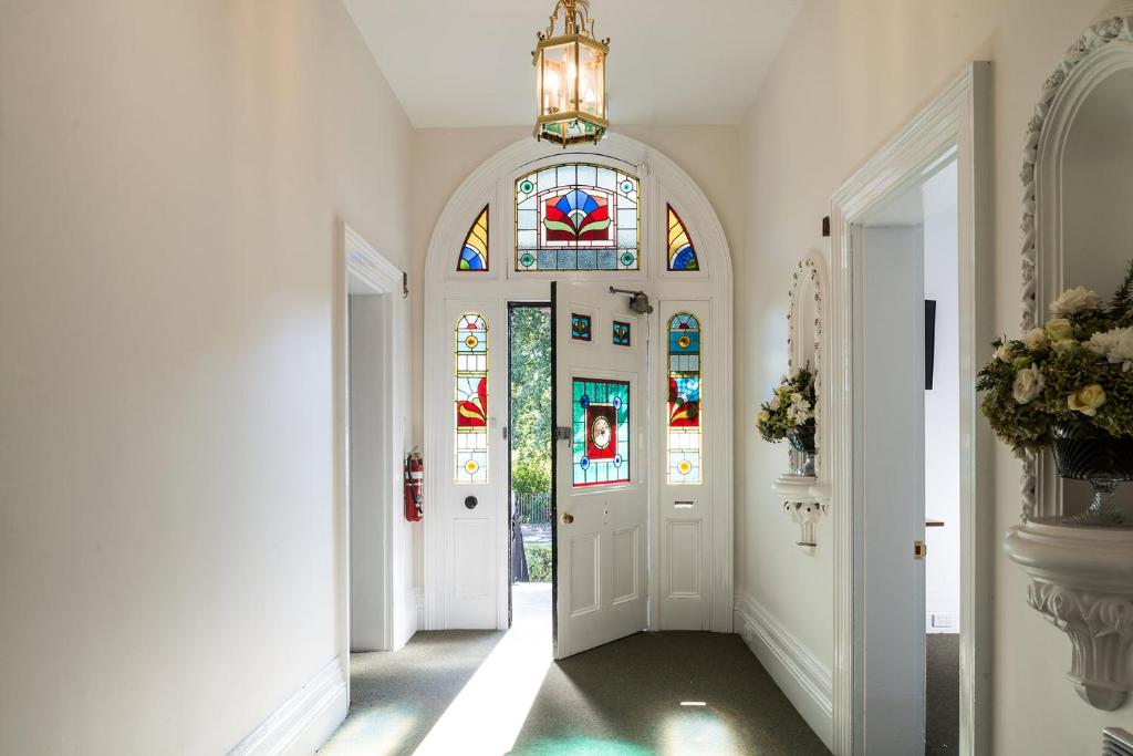 a hallway with a door with a stained glass window at The Florance in Launceston
