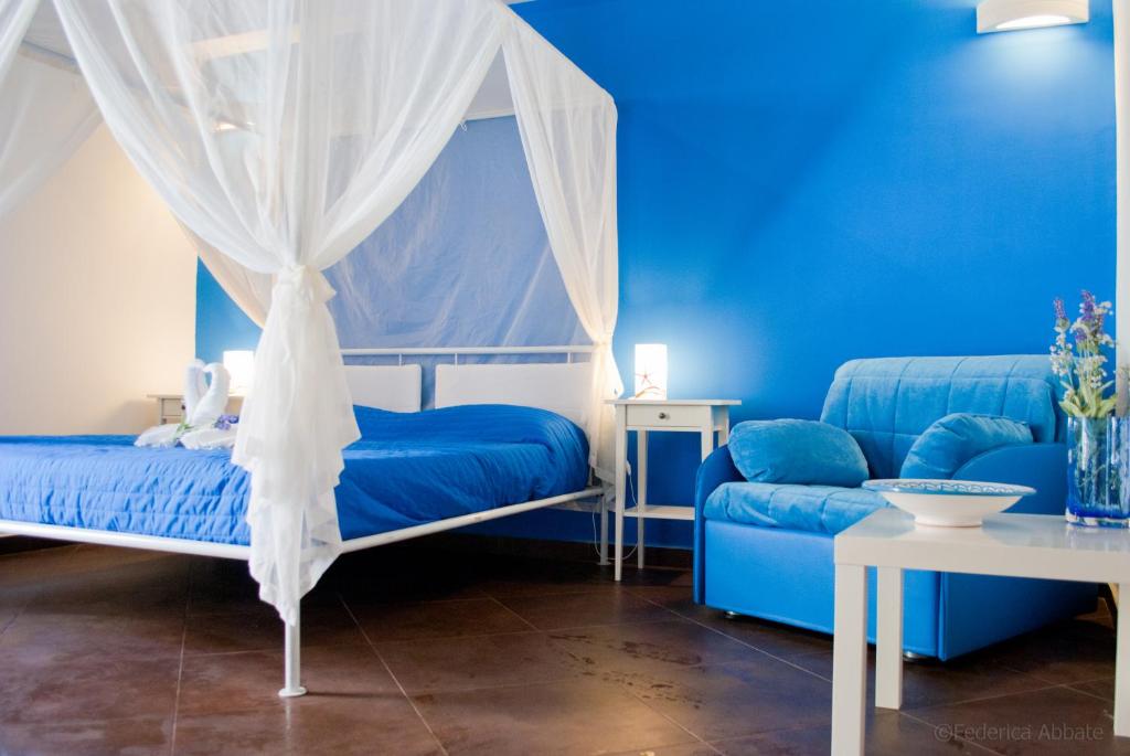 um quarto azul com uma cama e um sofá em B&B Carella em Palermo