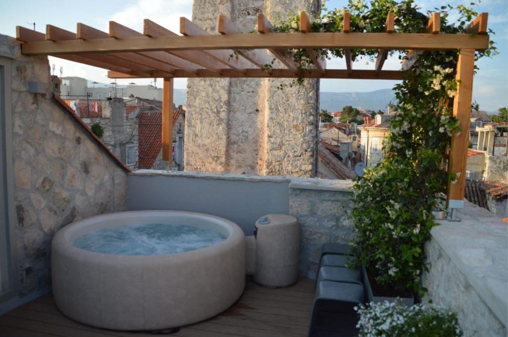 a hot tub on a patio with a pergola at Apartment Luxury Palace No1 in Split