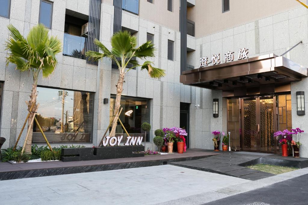 a building with a palm tree in front of it at Joy Inn in Lugang