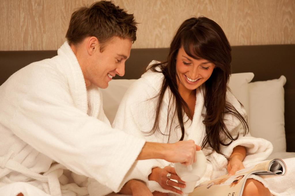a man and a woman in a bed with a baby at Lifehouse Spa And Hotel in Frinton-on-Sea