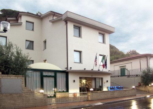 Un grande edificio bianco con una bandiera americana sopra. di Hotel I' Fiorino a Montelupo Fiorentino