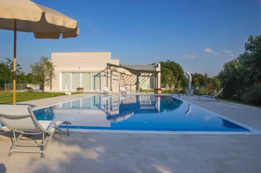 - une piscine avec une chaise et un parasol dans l'établissement Agriturismo Dell'Orto Apartments, à Vérone