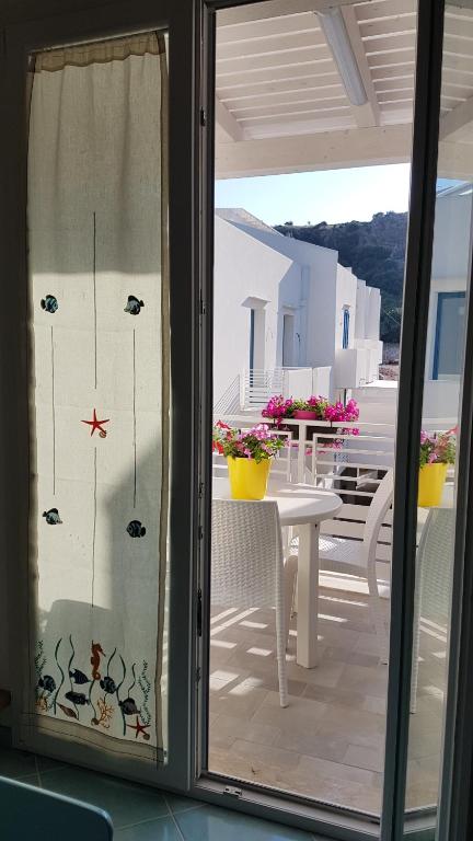 a sliding glass door of a patio with a table and chairs at Aquamarine Apartment Nel Cuore Di San Vito in San Vito lo Capo