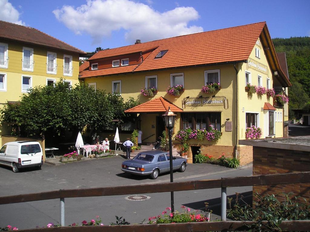 un coche azul estacionado frente a un edificio amarillo en Gasthaus Breitenbach, en Bad Brückenau