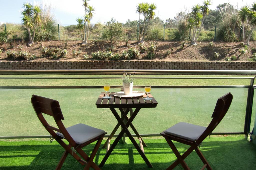 a table with two chairs and two glasses of wine at The Surf Studio - Ericeira in Ericeira