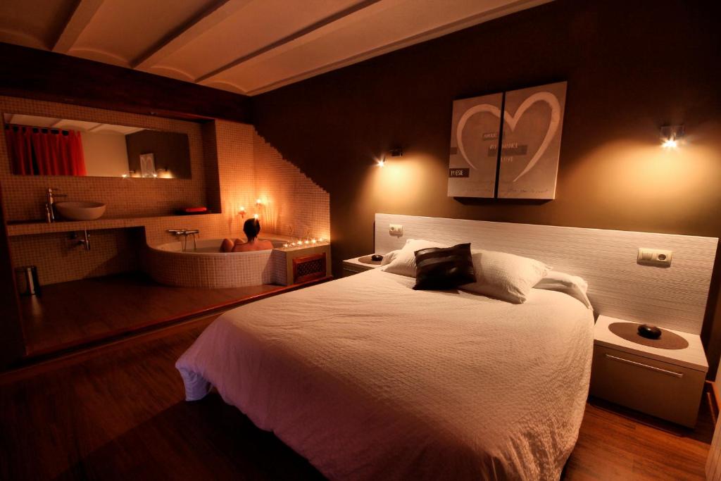 a bedroom with a bed and a bathroom with a sink at La Casa del Mercat in Villafranca del Cid