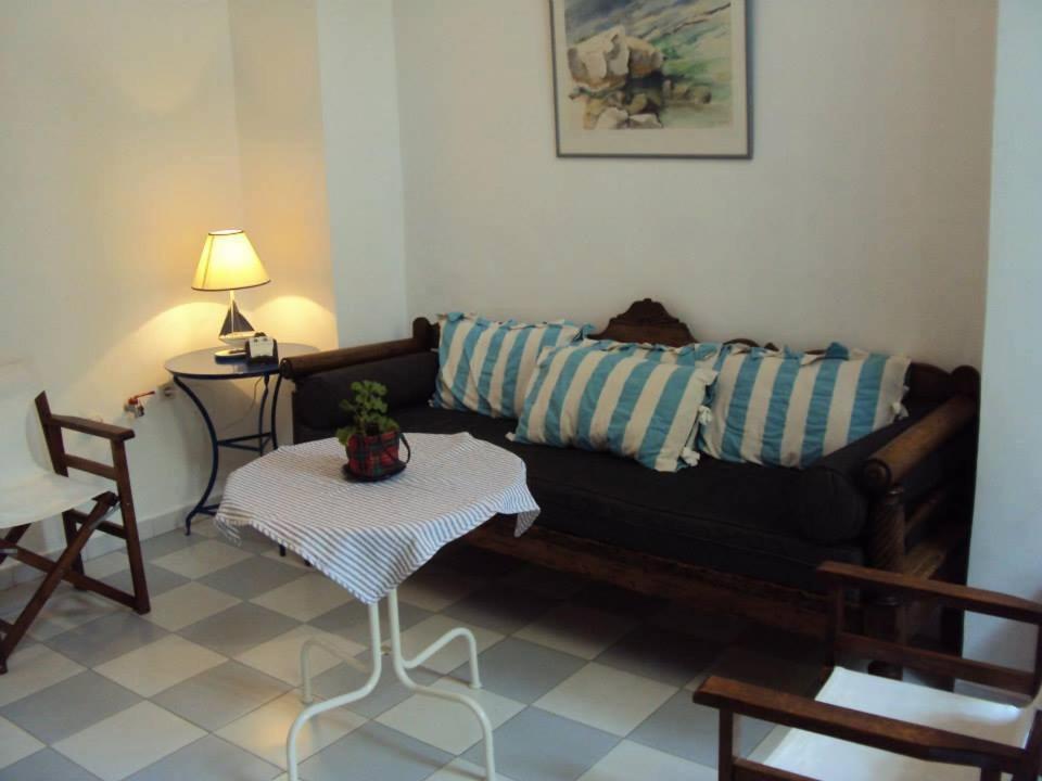sala de estar con sofá negro y mesa en Albatros en Symi