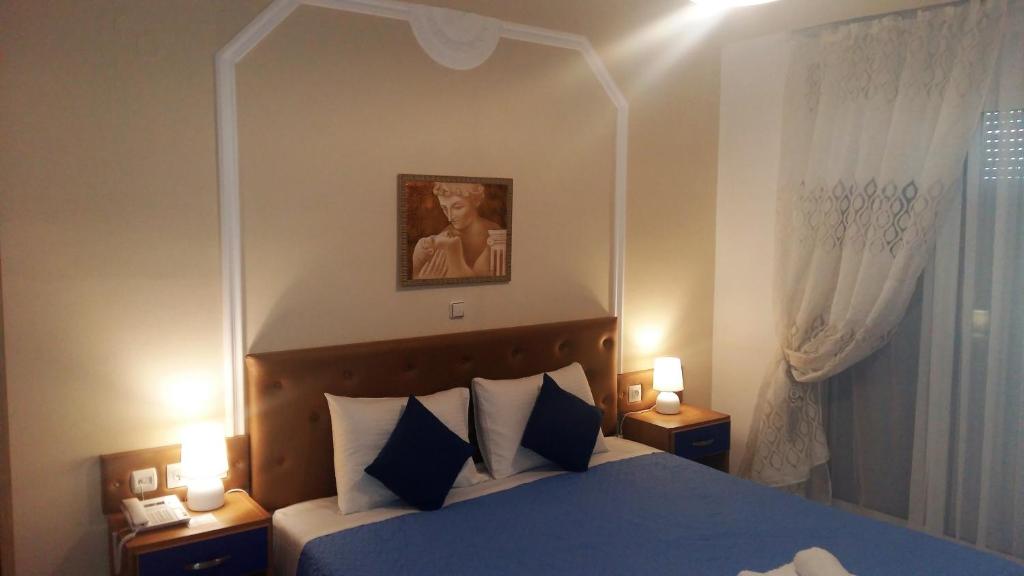 a bedroom with a bed with a blue comforter at Pantheon Deluxe Apartments in Archangelos