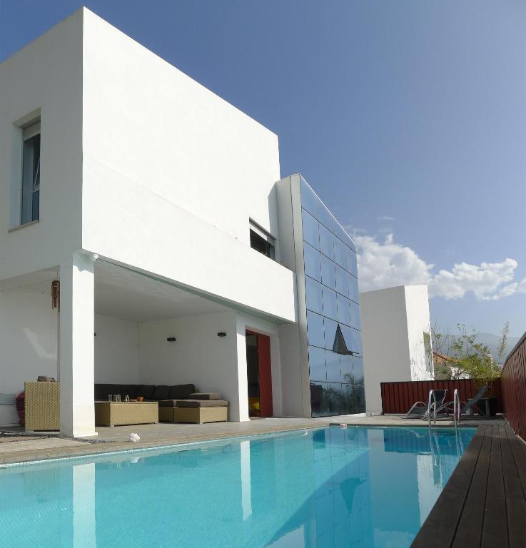 a house with a swimming pool in front of a building at Villa Cristal in La Orotava