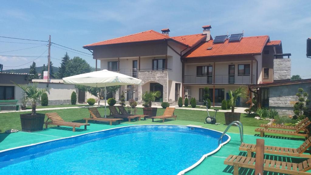 uma casa com piscina em frente a uma casa em Sveti Nikola Villas near Borovets em Shiroki Dol