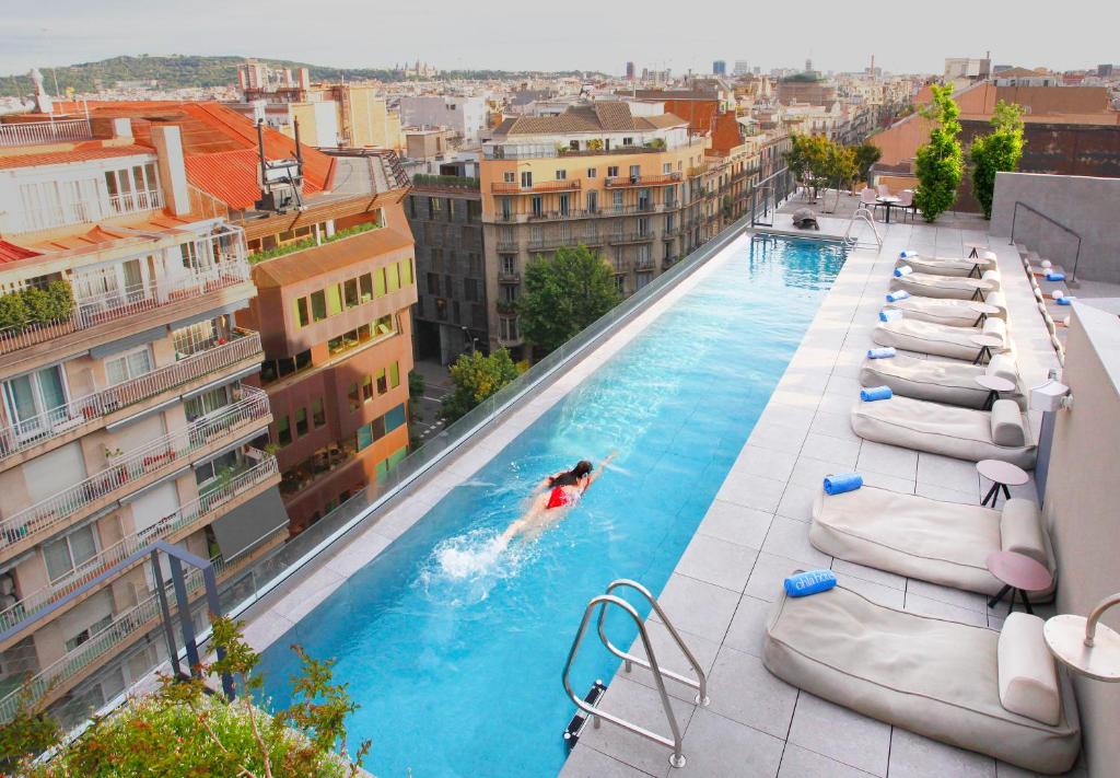a man laying in a pool next to a swimming pool at Ohla Eixample in Barcelona