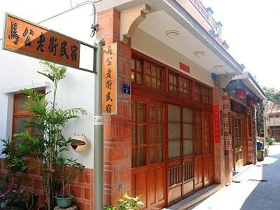 a building with orange doors and a sign on it at Makung Traditional Homestay in Magong