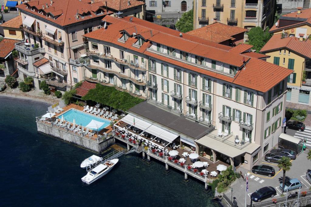 une vue aérienne sur un hôtel avec un bateau dans l'eau dans l'établissement Hotel Bellavista, à Menaggio