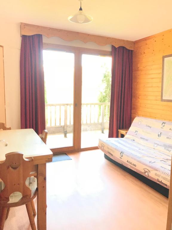 a bedroom with a bed and a desk and a window at Appartement 2 pieces Orelle les trois Vallées 6 personnes in Orelle
